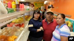 FILE - Diana Resendiz, from left, Alberto Resendiz and Maribel Resendiz pose for a photo at their business Mr. Tutis Fruties in Florida City, Florida, June 27, 2017. 