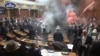 This image taken from video released by the National Assembly of Serbia in Belgrade on March 4, 2025, shows opposition lawmakers lighting flares and discharging suspected tear gas during a session of parliament in support of ongoing corruption protests.