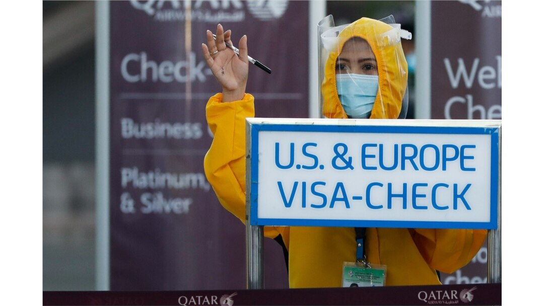 Una trabajadora de Qatar Airways, usando traje de protección contra el coronavirus, llama a pasajeros a chequearse en el aeropuerto internacional de Ninoy Aquino en Ciudad Pasay, Metro Manila, Filipinas.