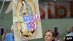 Una mujer sostiene una imagen de la Virgen María con las palabras Venezuela libre, durante una vigilia convocada por la oposición exigiendo la libertad de los presos políticos arrestados durante las protestas tras la controvertida reelección presidencial.