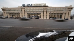 FILE - Cars pass by the former Russian RIA Novosti information agency headquarters in Moscow, Dec. 9, 2013. Major brands in the export division of Russian media include RT, the RIA Novosti news agency, Sputnik and the Voice of Russia radio station.