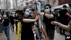 香港抗议者星期天（7月28日）在中环分发雨伞。美联社