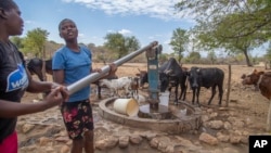 FILE - File — Villagers pump water at a borehole in Mudzi, Zimbabwe, July 2, 2024.as the WFP says months of drought in southern Africa, triggered by the El Nino, has had a devastating impact and caused the region's worst hunger crisis in decades. 