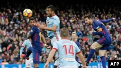 L'attaquant argentin de Barcelone Lionel Messi du FC Barcelone, à droite, joue la balle de la tête contre le RC Celta de Vigo au stade Camp Nou de Barcelone le 2 décembre 2017.