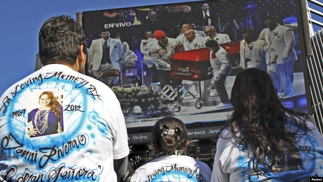 Admiradores de La Diva de la Banda observan en una pantalla los funerales de la cantante.