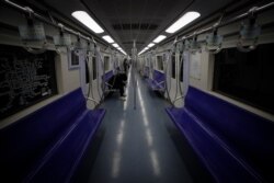 Few commuters ride in an almost empty subway train in Beijing, Feb. 24, 2020.