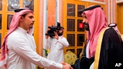 FILE - Photo released by Saudi Press Agency, SPA, shows Saudi Crown Prince Mohammed bin Salman (R) shaking the hand of Salah Khashoggi, son of Jamal Khashoggi, in Riyadh, Saudi Arabia, Oct. 23, 2018.