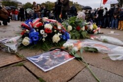 FILE - Floral tributes to Samuel Paty, the French teacher who was beheaded on the streets of the Paris suburb of Conflans St Honorine, are seen at the Place de la Republique, in Lille, France, Oct. 18, 2020.