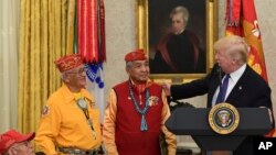 Presiden AS Donald Trump dalam upacara di Gedung Putih hari Senin (27/11), yang diselenggarakan untuk menghormati Fleming Begaye, Thomas Begay dan Peter MacDonald; tiga dari 13 Navajo Code Talkers.