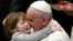 FILE - Pope Francis holds a child as he leads the weekly audience in Paul VI's hall at the Vatican, Jan. 20, 2016.