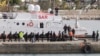 Migrants board an Italian coast guard vessel as part of a transfer operation from the asylum processing centers in Albania back to Italy following a court decision in Rome, at the port of Shengjin, Albania, on Feb. 1, 2025.