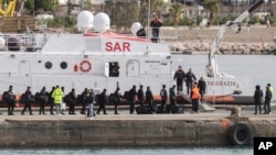 Migrants board an Italian coast guard vessel as part of a transfer operation from the asylum processing centers in Albania back to Italy following a court decision in Rome, at the port of Shengjin, Albania, on Feb. 1, 2025.