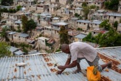 Antony Exilien secures the roof of his house in response to Tropical Storm Elsa, in Port-au-Prince, Haiti, July 3, 2021.