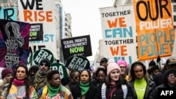 Manifestantes durante a “Marcha do Povo” em Washington, DC, a 18 de janeiro de 2025, antes da tomada de posse do Presidente eleito dos EUA, Donald Trump.