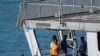 Migrants stand on the Italian navy ship Libra that arrived in Albania as part of a deal with Italy to process thousands of asylum-seekers caught near Italian waters, in Shengjin, Albania, Oct. 16, 2024. 