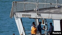 Migrants stand on the Italian navy ship Libra that arrived in Albania as part of a deal with Italy to process thousands of asylum-seekers caught near Italian waters, in Shengjin, Albania, Oct. 16, 2024. 