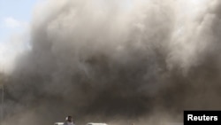 People react as dust rises after explosions hit Aden airport, upon the arrival of the newly-formed Yemeni government in Aden, Yemen, Dec. 30, 2020. 