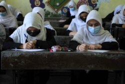 FILE - Schoolgirls attend class in Herat on Aug. 17, 2021, following the Taliban stunning takeover of the country.