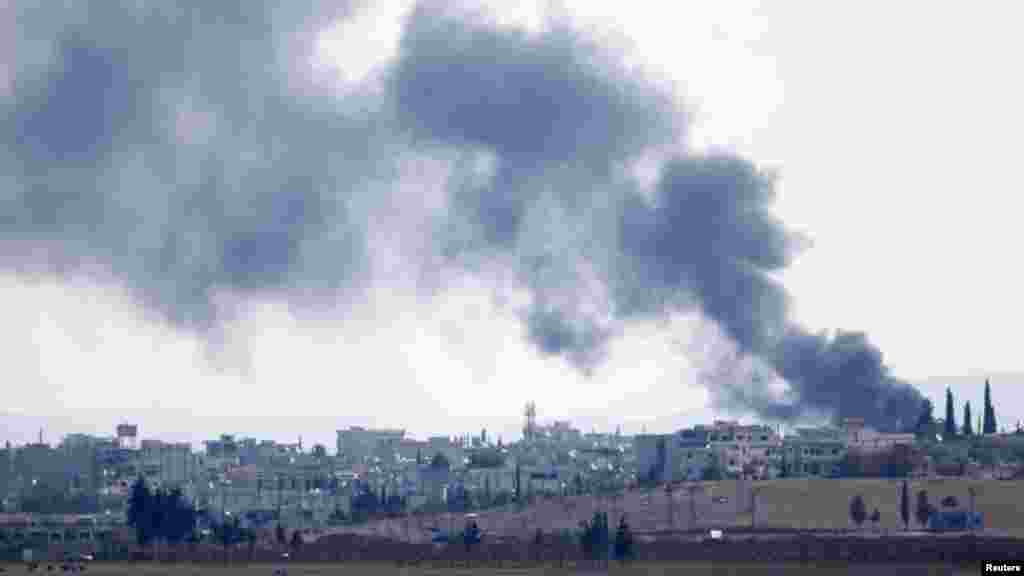 Smoke rises from the Syrian town of Kobani, seen from the Mursitpinar border crossing on the Turkish-Syrian border in the southeastern town of Suruc in Sanliurfa province, Oct. 18, 2014. 