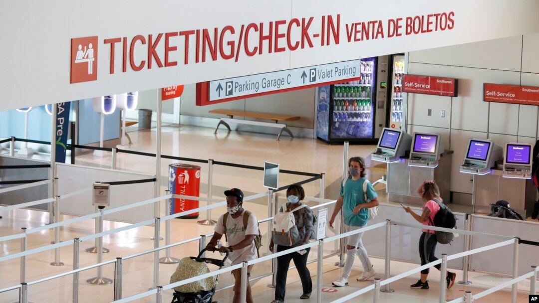 Passengers approach gate security for flights out of Love Field in Dallas, Texas, June 24, 2020.