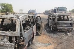 FILE - Burmt cars are seen after a deadly attack by suspected members of the Islamic State West Africa Province (ISWAP) in Auno, Nigeria, Feb. 9, 2020.