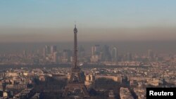 A small-particle haze hangs above the skyline, with the Eiffel Tower and the La Defense business district that is seen in the distance, in Paris, France, Dec. 1, 2016. 