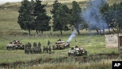 Syrian soldiers deploy in the village of Arida, as seen from the northern Lebanese village of Wadi Khaled near the Lebanese-Syrian border, May 20, 2011.