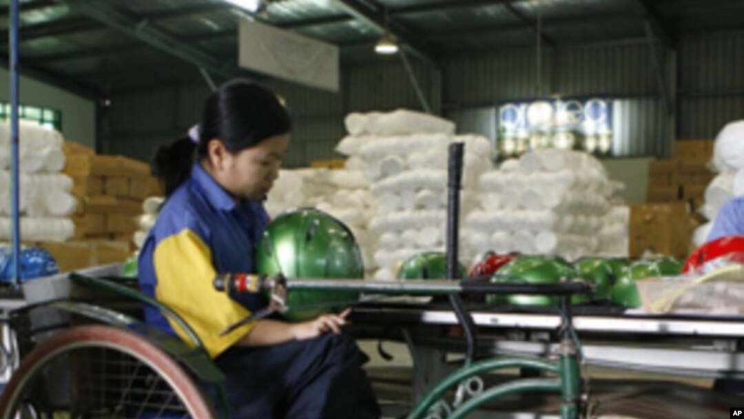 A disabled woman works at a helmet factory in Hanoi (File Photo)