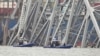 Kapal milik polisi bergerak di dekat kapal kargo yang terjebak di struktur jembatan Francis Scott Key di Baltimore, Maryland, pada 27 Maret 2024. (Foto: AP/Steve Helber)