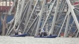 Kapal milik polisi bergerak di dekat kapal kargo yang terjebak di struktur jembatan Francis Scott Key di Baltimore, Maryland, pada 27 Maret 2024. (Foto: AP/Steve Helber)