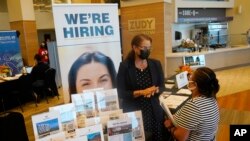 FILE - Marriott human resources recruiter Mariela Cuevas, left, talks to Lisbet Oliveros, during a job fair at Hard Rock Stadium, Sept. 3, 2021, in Miami Gardens, Florida.. 