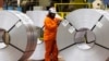 A worker inspects a steel coil on the factory floor of the ArcelorMittal Dofasco steel mill in Hamilton, Ontario, Canada, March 12, 2025. 