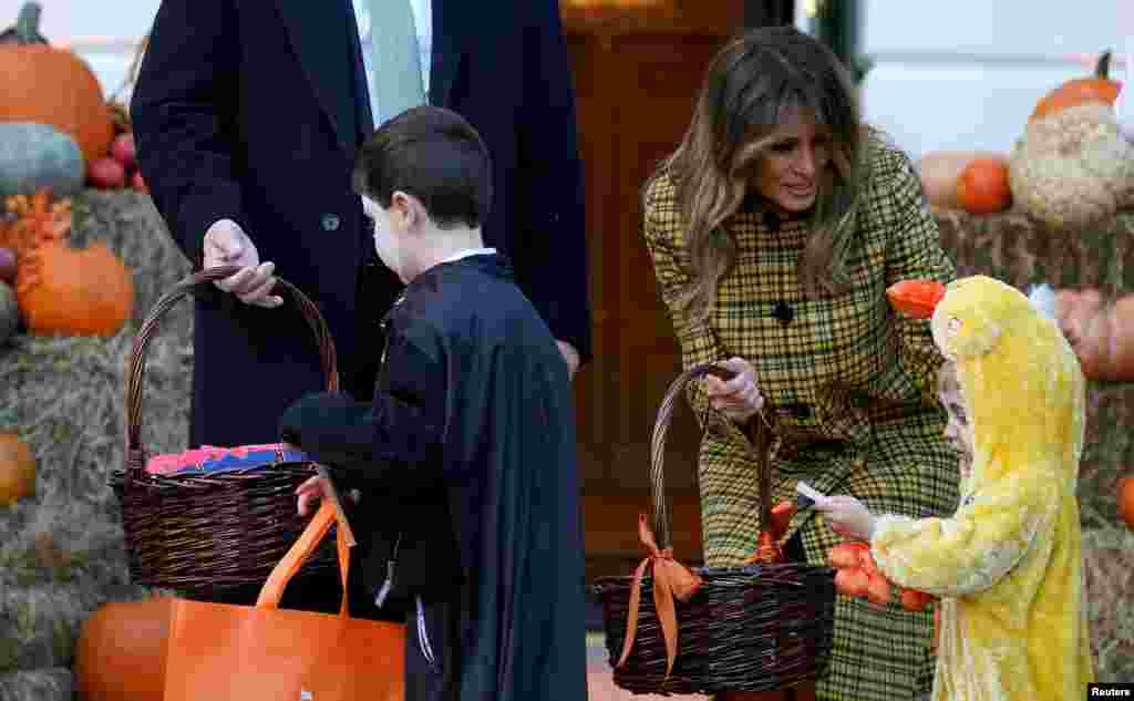 El presidente Trump y la primera dama Melania Trump no estaba disfrazados en su fiesta de Halloween, pero sonrieron, hablaron y posaron para fotos con los niños invitados mientras les entregaban dulces de unas cestas de mimbre. Domingo 28 de octubre de 2018. 