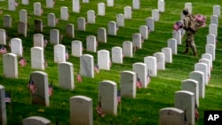 Un oficial de Infantería de Estados Unidos recorre el Cementerio Nacional de Arlington, el jueves 25 de mayo de 2023, para instalar banderas en el camposanto de cara a la conmemoración del Día de los Caídos.