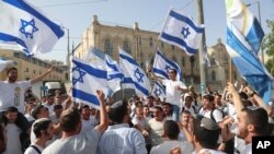 FILE - In this May 10, 2021, file photo, Israelis wave national flags during a Jerusalem Day parade, in Jerusalem. 