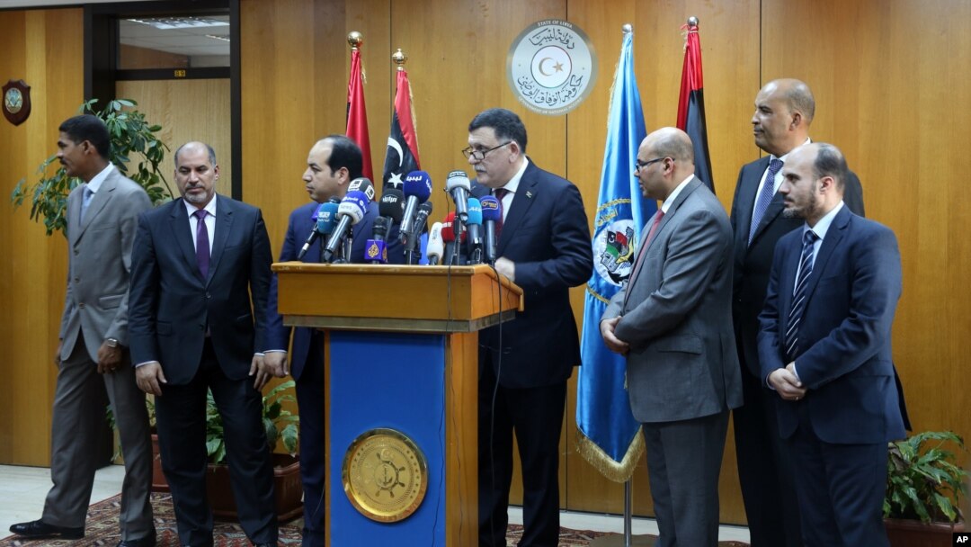 Fayez Seraj, flanked by members of the Presidential Council, speaks during a news conference at the Mitiga Naval Base in Tripoli, Libya, March, 30, 2015.