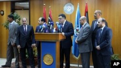 Fayez Seraj, flanked by members of the Presidential Council, speaks during a news conference at the Mitiga Naval Base in Tripoli, Libya, March, 30, 2015.