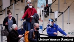 Seorang petugas Badan Keamanan Transportasi AS (TSA) mengarahkan para calon penumpang di tempat pemeriksaan di Bandara Internasional Seattle-Tacoma di SeaTac, Washington, 12 April 2021. (Foto: Lindsey Wasson/Reuters) 