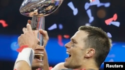 New England Patriots' quarterback Tom Brady is reflected multiple times in the Vince Lombardi trophy as he celebrates after his team defeated the Atlanta Falcons to win Super Bowl LI in Houston, Texas, Feb. 5, 2017. 