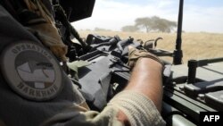 FILE - A soldier of France's Barkhane mission holds a weapon as he patrols in central Mali, in the border zone with Burkina Faso and Niger, Nov. 1, 2017. Two members of the French counterterrorism force in Mali were killed Wednesday, authorities said.
