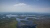 FILE - Swamps surround a village in Ayod County, northern South Sudan, July 3, 2018. Rains that began Sept. 15, 2019, caused flash floods that have displaced thousands of people in the rebel-controlled county.