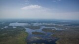 FILE - Swamps surround a village in Ayod County, northern South Sudan, July 3, 2018. Rains that began Sept. 15, 2019, caused flash floods that have displaced thousands of people in the rebel-controlled county.