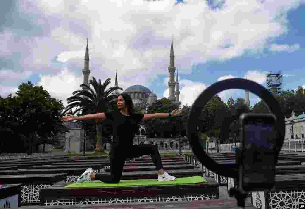 터키 이스탄불의 술탄 아흐멧 모스크 앞에서 요가 강사가 유튜브로 요가 포즈를 생중계하고 있다. 