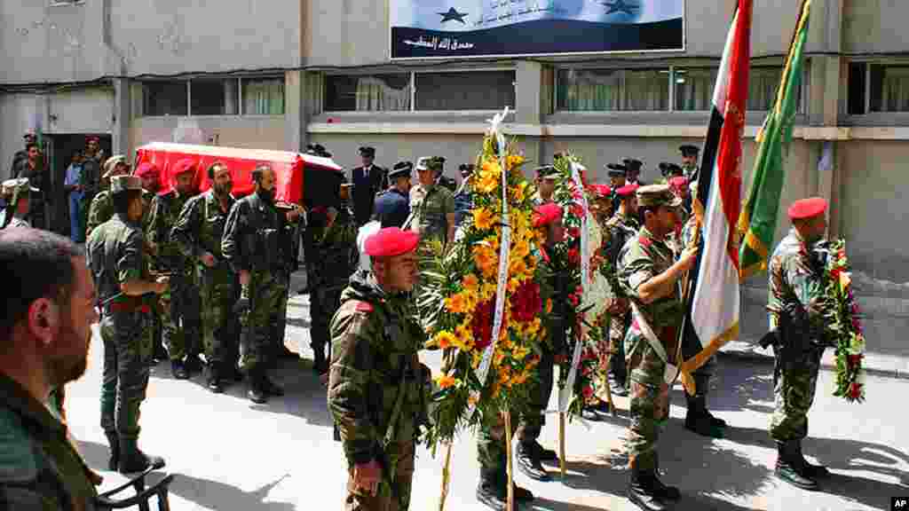 Syrian soldiers carry the coffin of the commander of the pro-government National Defense Forces, Hilal Assad, during his funeral at a hospital in Latakia province, March 24, 2014. (SANA)