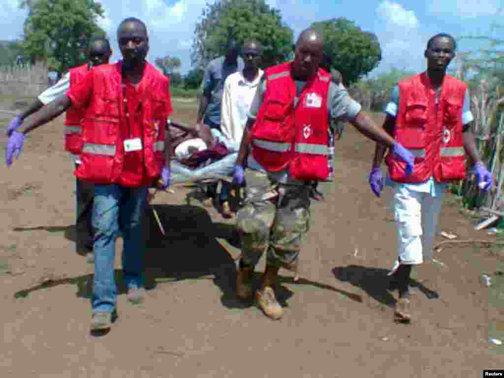 Members of the Kenya Red Cross carry an injured man after an attack in his village at Tana River district.