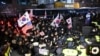 Police officers stand guard as pro-Yoon supporters, back, try to enter the compound of the Seoul Western District Court in Seoul on Jan. 18, 2025, as the court weighs whether to extend the detention of impeached South Korea President Yoon Suk Yeol.