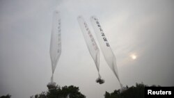 Balloons containing leaflets denouncing Pyongyang are seen after former North Korean defectors released them towards North Korea at a field near the demilitarized zone separating the two Koreas in Gimpo, west of Seoul June 24, 2012. 