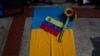 Una bandera de Venezuela y un girasol sobre una bandera Ucrania durante una protesta contra la invasión rusa, frente a las oficinas de la Unión Europea en Caracas, el 3 de marzo de 2022.
