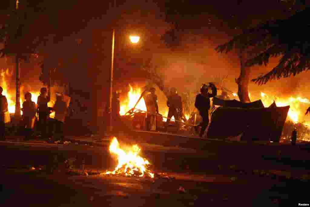 Police burn tents of protesters who staged a sit-in for weeks in front of the presidential palace, during clashes between protesters and police, in Cairo, Feb. 1, 2013.