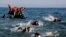 FILE - Migrants whose boat stalled at sea while crossing from Turkey to Greece swim to approach the shore of the island of Lesbos, Greece, Sept. 20, 2015. 
